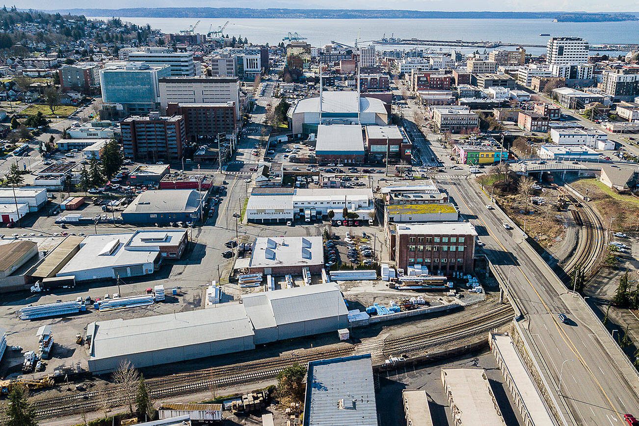 Aerial view of downtown Everett, WA with a stadium, buildings, and waterfront in the distance.