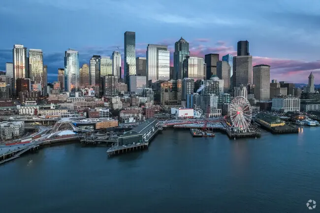 Seattle, WA, skyline with Ferris wheel at sunset.