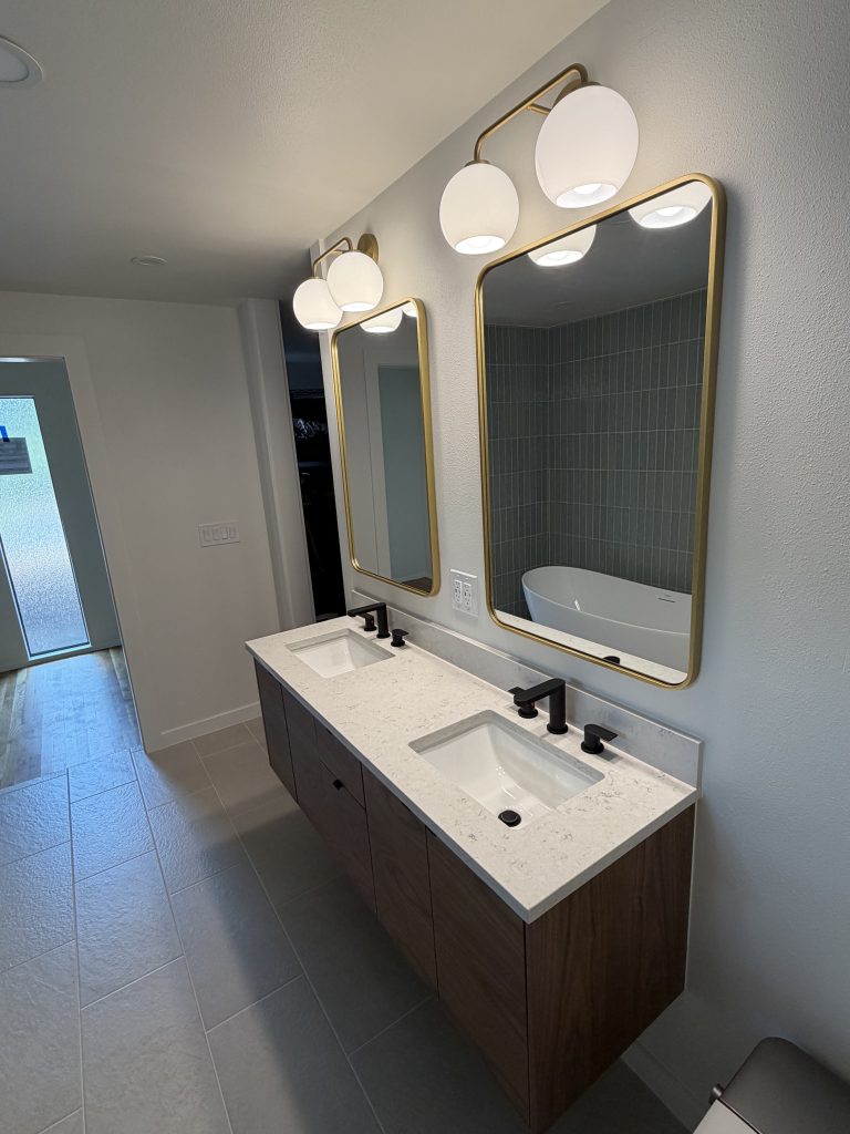 Double vanity with gold mirrors in the finished bathroom remodel