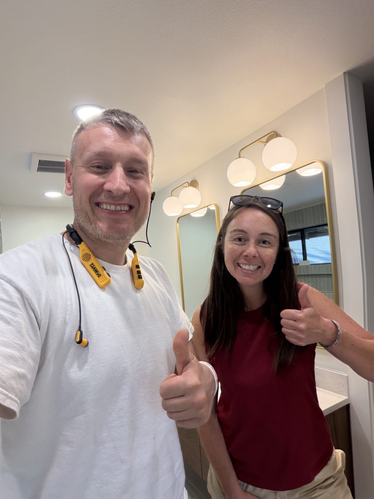 Thumbs up in the finished bathroom — happy client with YSG Construct