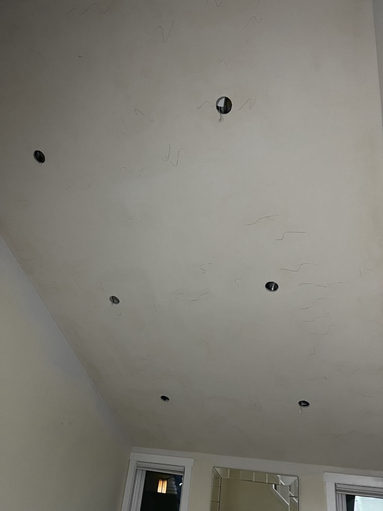Ceiling with recessed light cutouts after popcorn removal and skim coating by YSG Construct