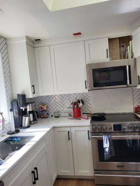 Bothell kitchen from a second angle before roof leak cleanup — upper cabinets still in place