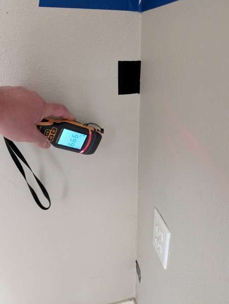 Moisture meter reading 99.9 on a basement wall in Brier — water damage inspection by YSG Construct