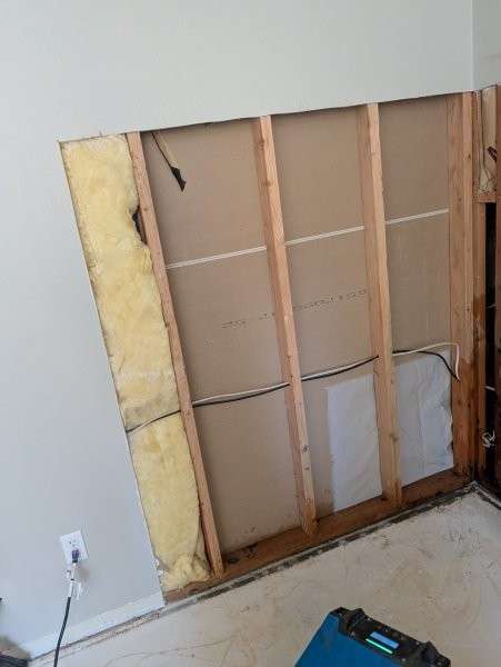 Opened basement wall framing after drywall removal — water damage restoration in Brier, WA by YSG Construct