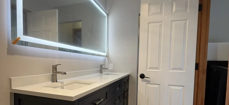 Finished bathroom remodel with double vanity and backlit LED mirror by YSG Construct