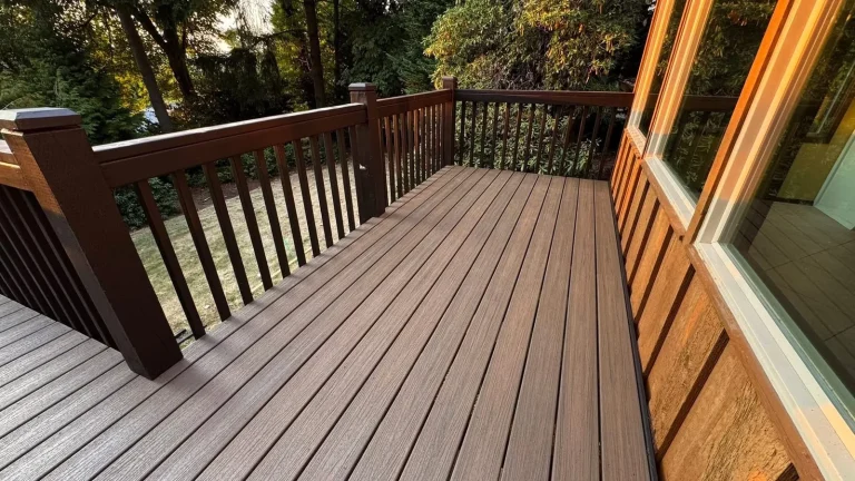 Brown composite deck with matching dark railing along the house, built by YSG Construct