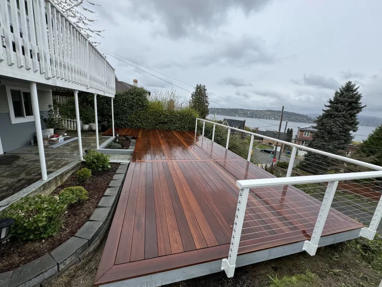 Long brown deck with white railing overlooking the water, YSG Construct decking project
