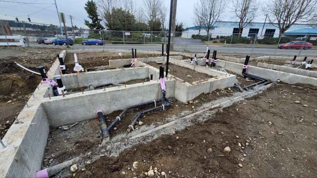 Poured concrete monolithic strip footings with underground utility pipes in Tacoma WA by YSG Construct