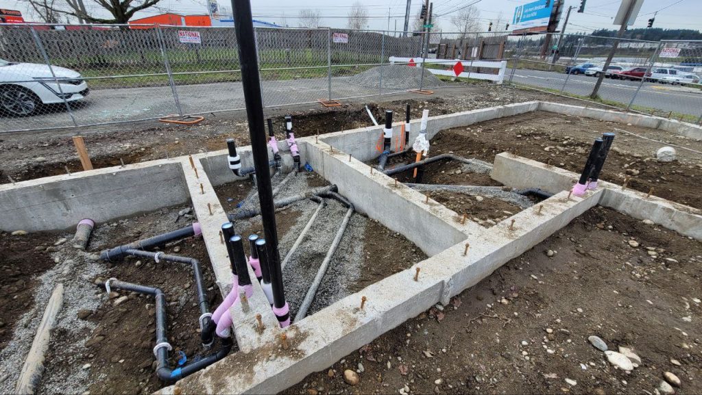 Concrete strip footings with underground plumbing pipes and roughed-in stacks in Tacoma WA by YSG Construct