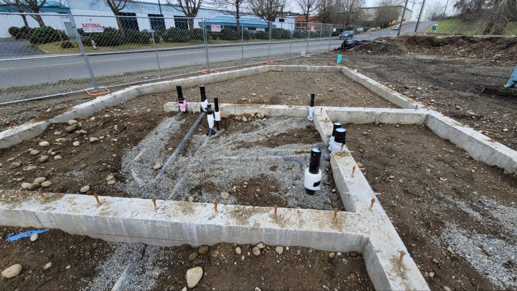 Overhead view of room footprint with roughed-in plumbing stacks inside concrete strip footings in Tacoma WA by YSG Construct