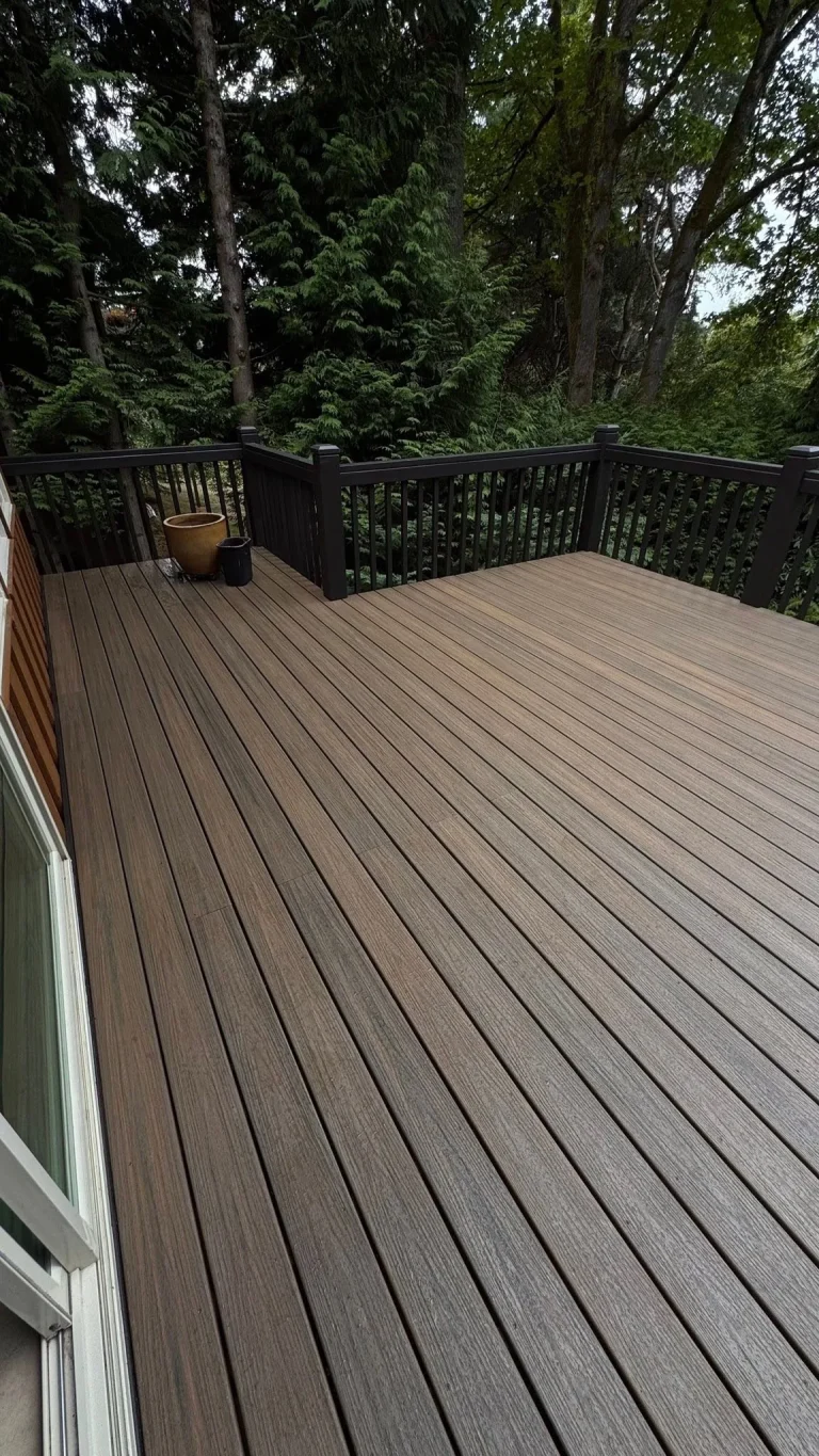 Large composite deck with dark railing surrounded by trees, YSG Construct decking project