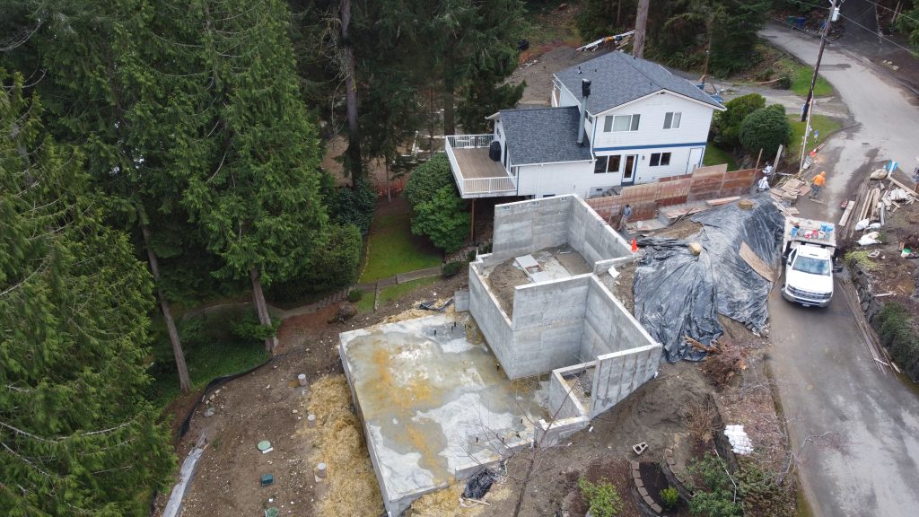 Aerial view of foundation site with crew and neighboring home — YSG Construct, Redmond / Eastside WA