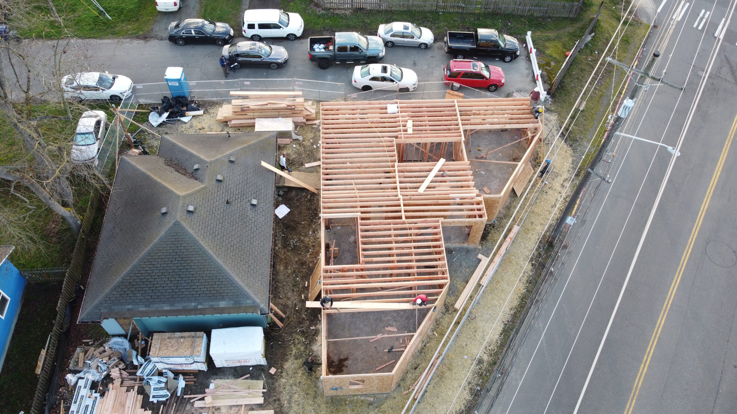 Aerial drone view of wood framing for a new house under construction with crew working on the frame — YSG Construct