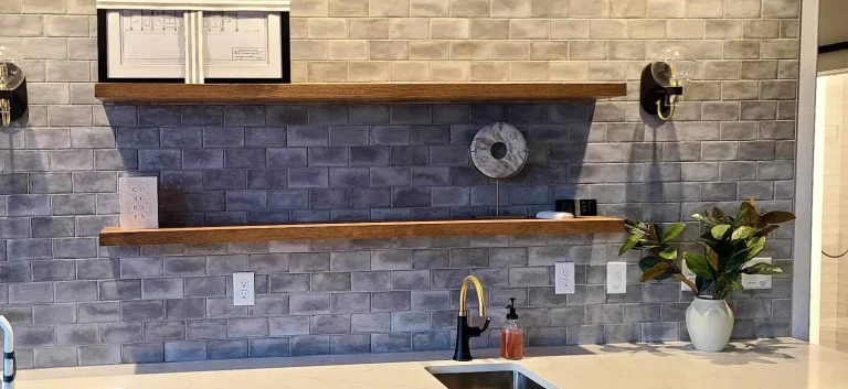 Kitchen remodel with stone tile backsplash and navy cabinets by YSG Construct