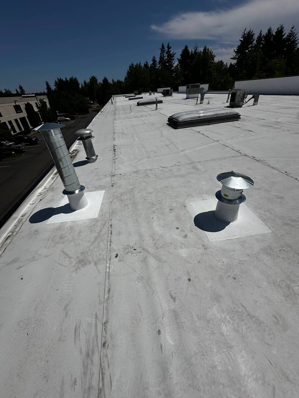 Wide view of commercial flat roof with sealed vents and HVAC units in Lacey WA