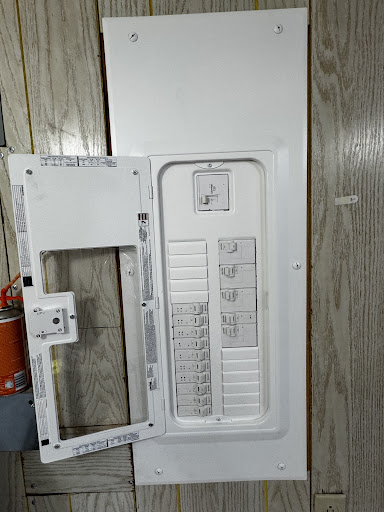 New electrical panel with labeled circuit breakers on wood-paneled wall