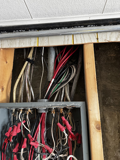Color-coded electrical conductors routed through wood framing to panel