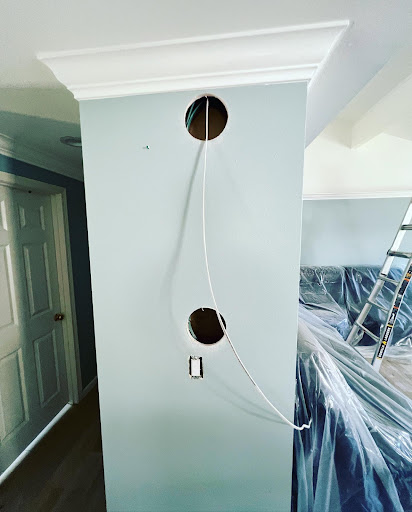 Round cutouts in wall with wiring for recessed light installation
