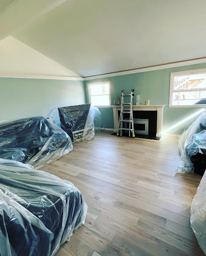 Living room with furniture covered in plastic sheeting during lighting installation
