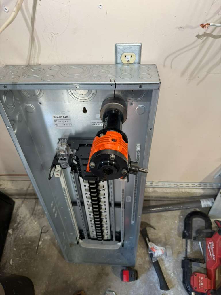 Knocking out panel holes with a hydraulic punch during a panel installation in Redmond, WA