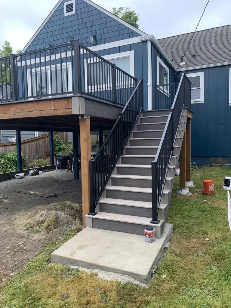 Raised composite deck with a long staircase and black railings, YSG Construct deck project