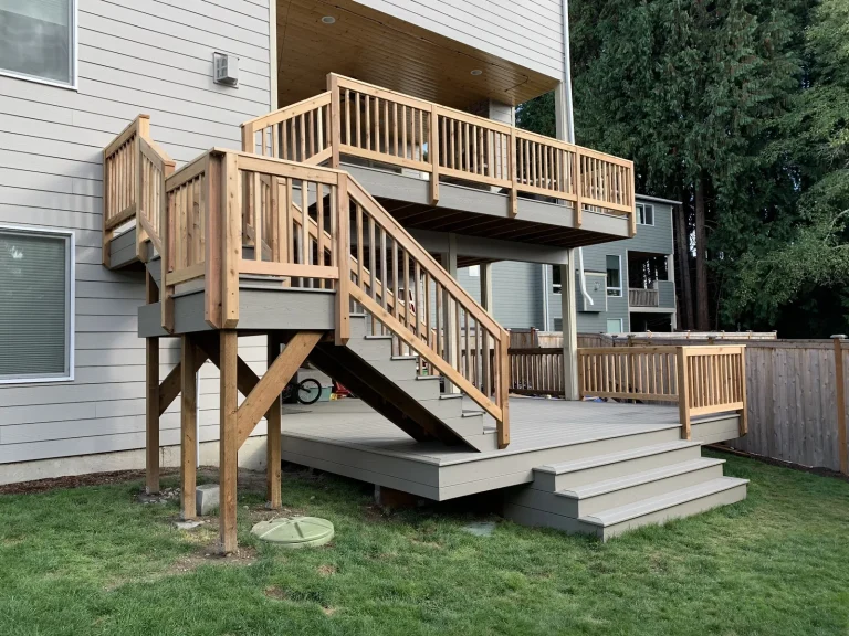 Two-story deck with wood railings and an exterior staircase, built by YSG Construct