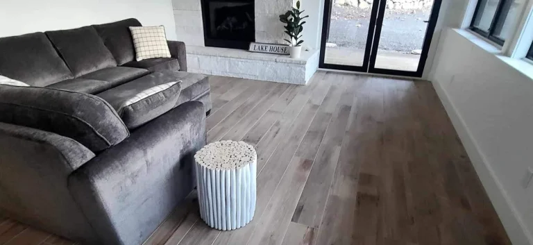 Whole-home remodel — finished living room with fireplace and wood floors by YSG Construct